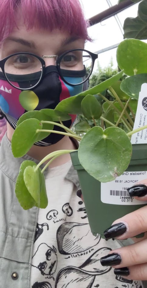 Photo of me with a peperomia while wearing my mask at a greenhouse. My nails were extra dope that day.